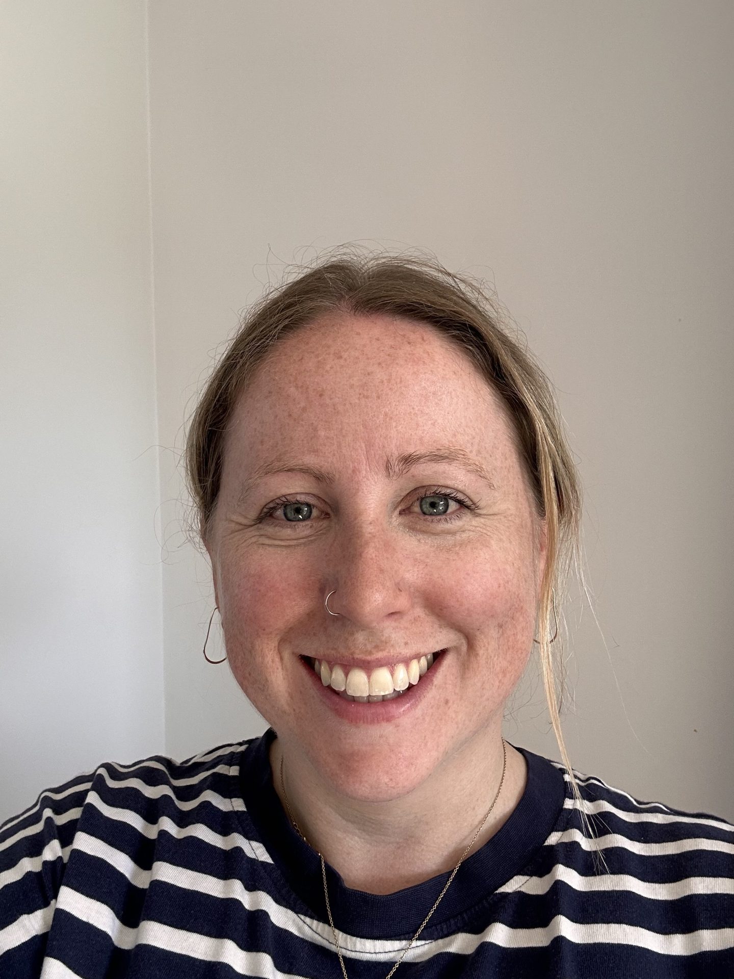 A woman is looking at the camera and smiling