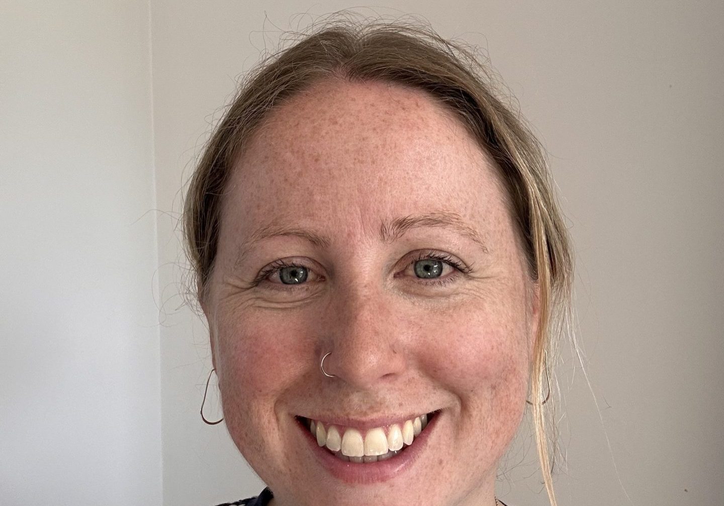 A woman is looking at the camera and smiling