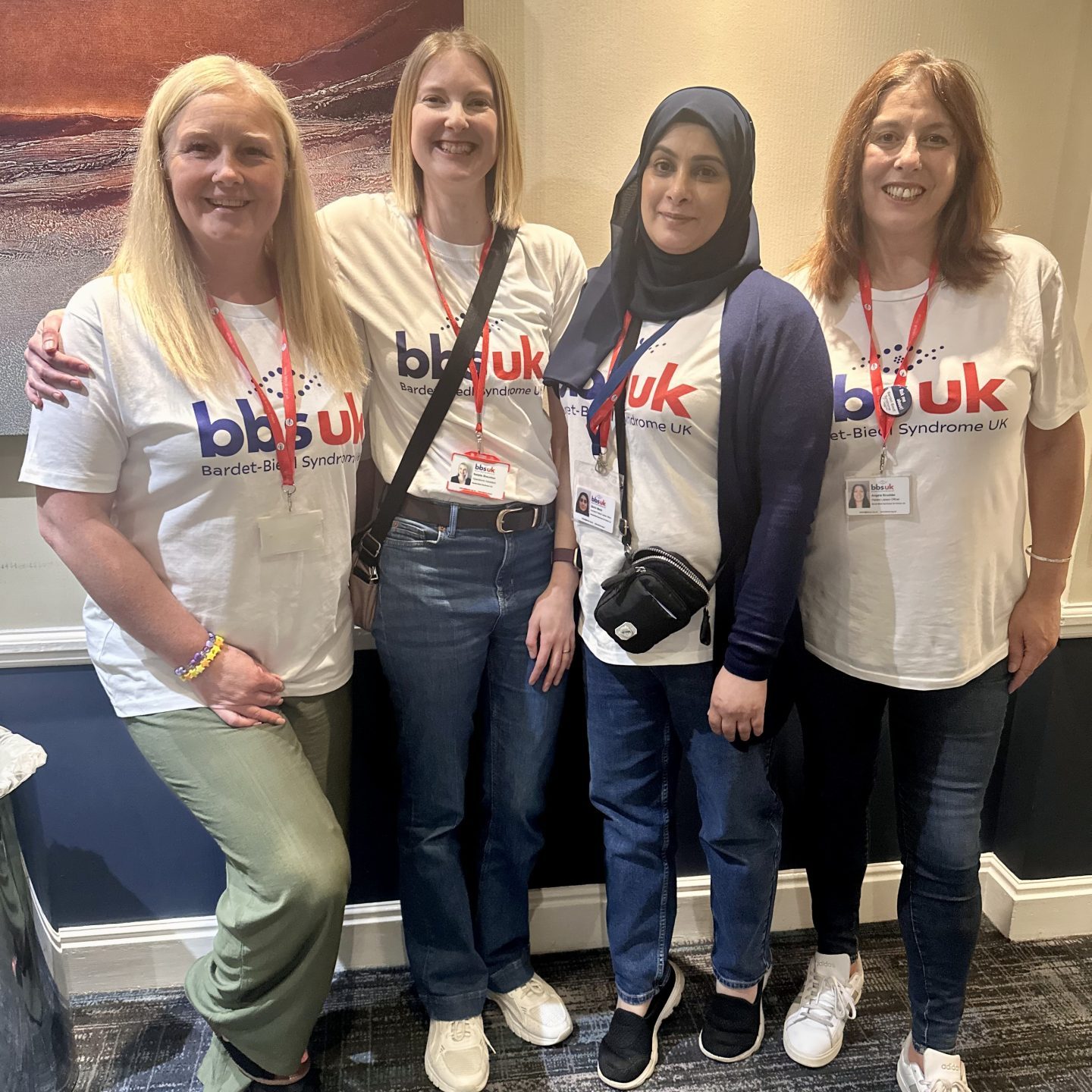 Four women are stood side by side smiling at the camera. They are wearing white BBS UK t-shirts.