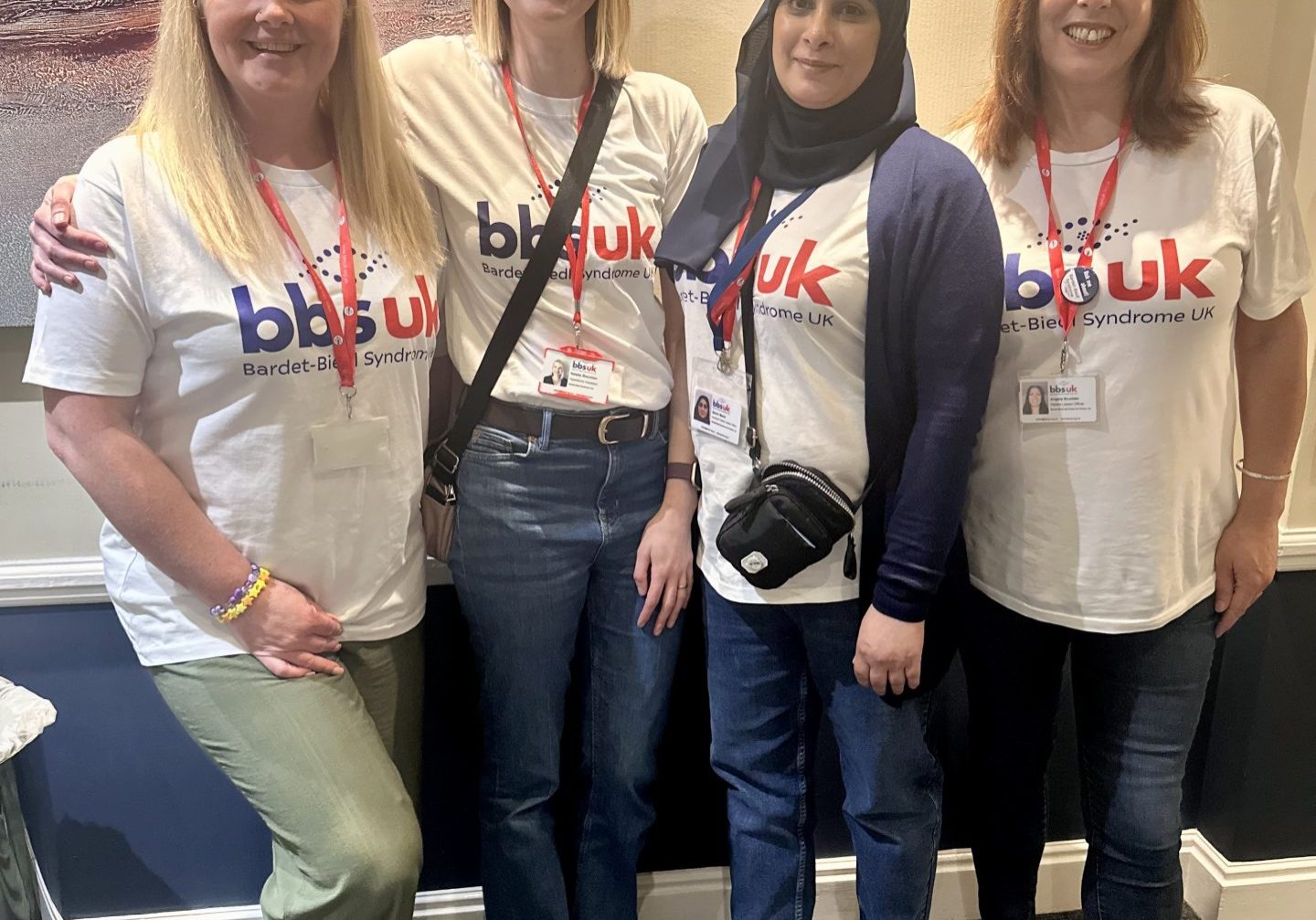 Four women are stood side by side smiling at the camera. They are wearing white BBS UK t-shirts.