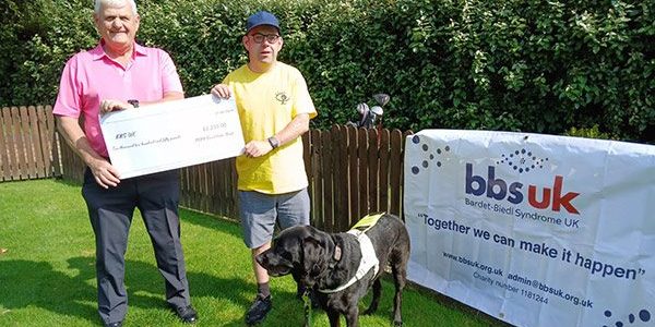 Graeme-Roache-golf-fundraiser-holding-cheque_W600